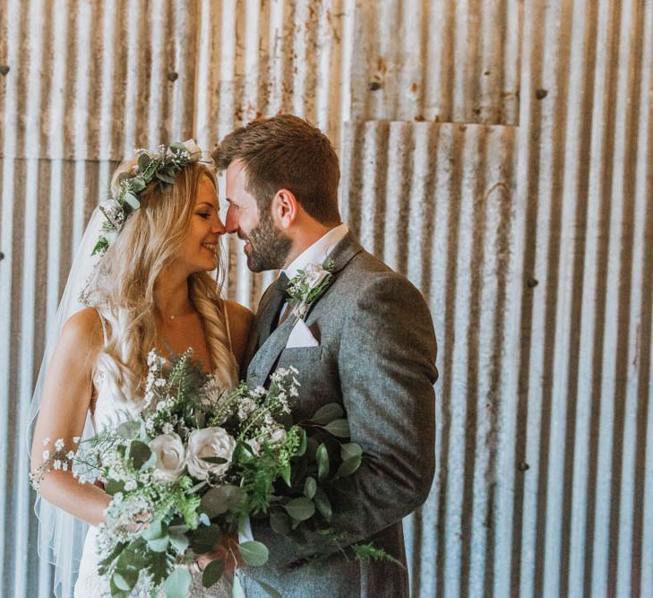 Bride in Lace Wedding Dress and Flowers Crown and Groom in Brown Wool Suit