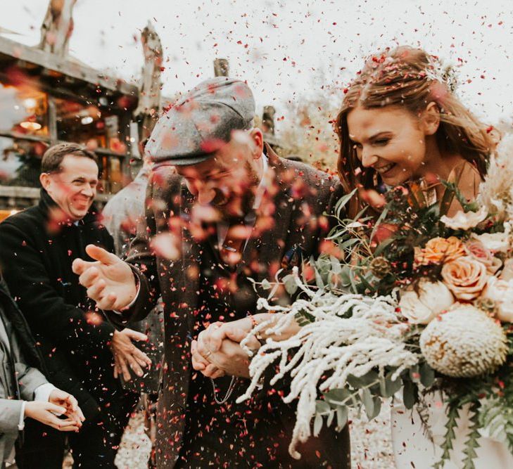 Confetti exit for bride and groom with large bouquet