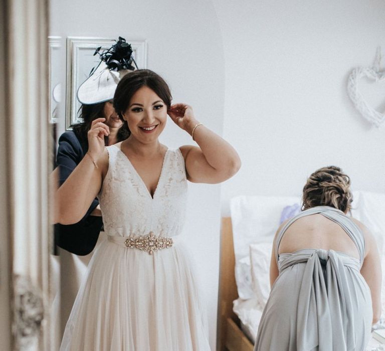 Bride on the wedding morning putting on her Catherine Deane Tamsin wedding dress