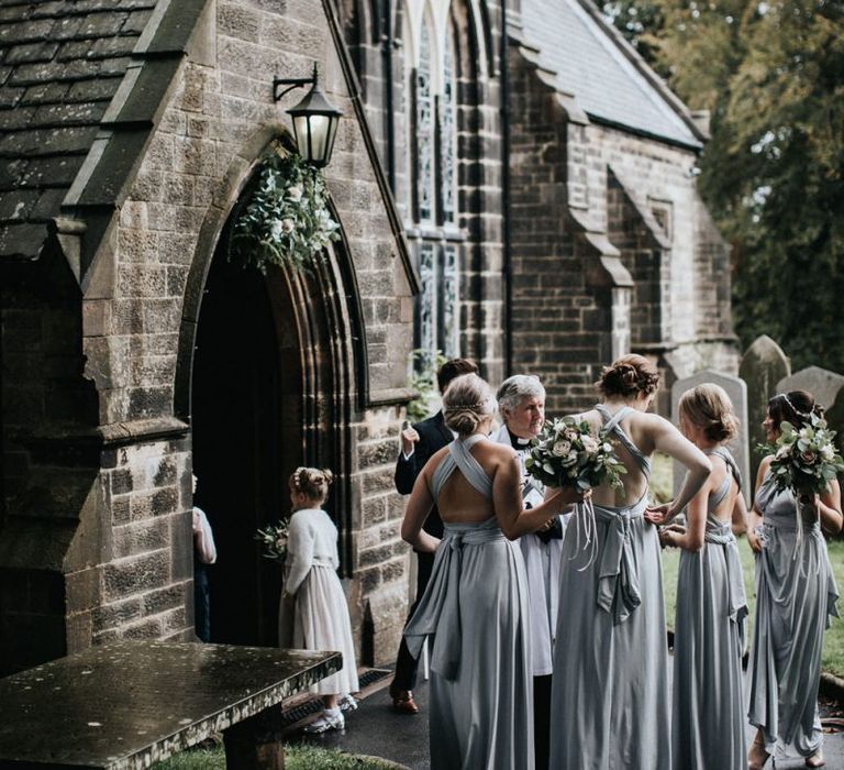 Bridal party in grey multiway bridesmaid dresses outside the church