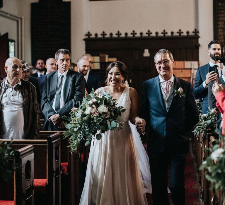 Bride walking down the aisle in a blush pink wedding dress