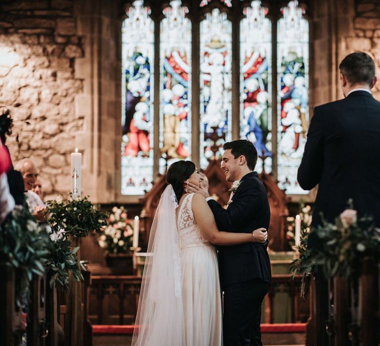 Groom kissing his bride at the altar