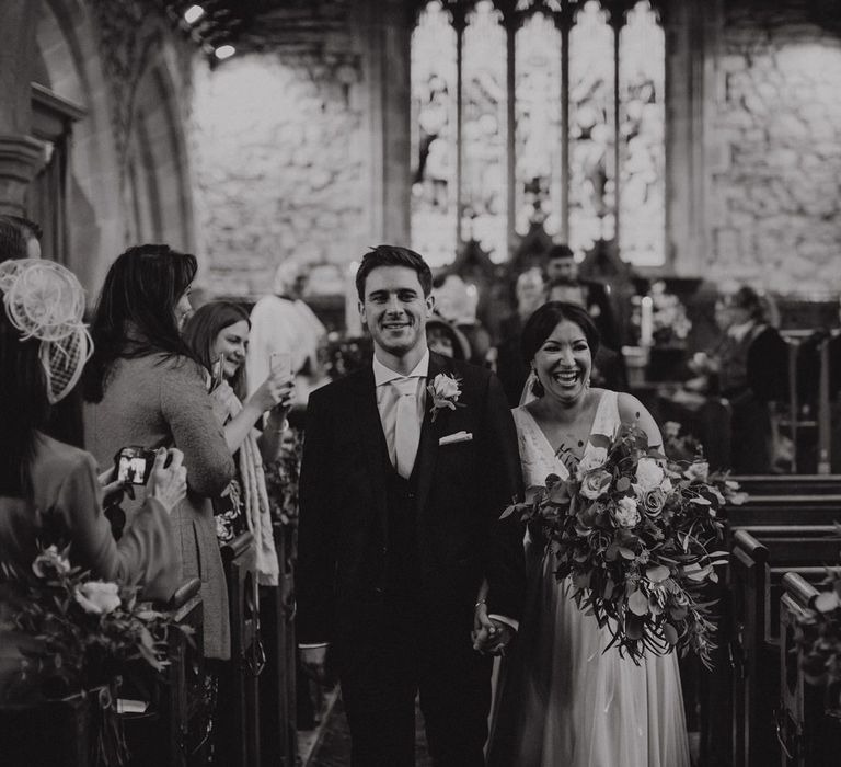 Bride and groom walking up the aisle married