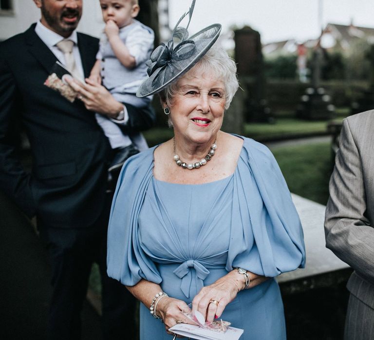 Wedding guests with lady in blue dress and hat