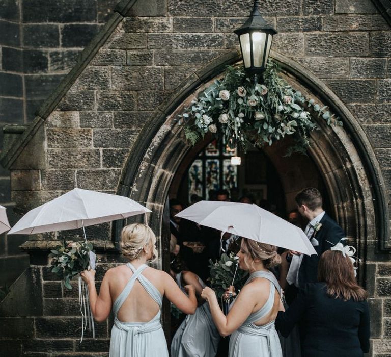 Bridal party standing outside the church in grey multiway bridesmaid dresses