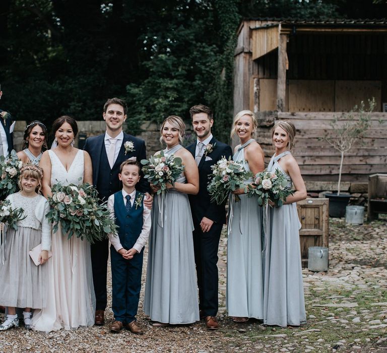 Wedding party portrait with bridal party in grey multiway bridesmaid dresses and bride in blush wedding dress