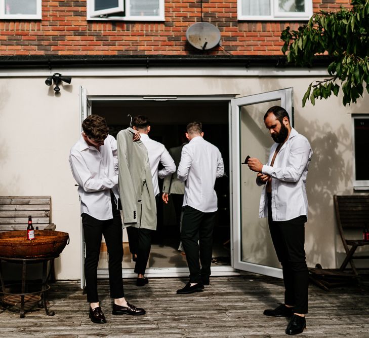 Groomsmen Getting Ready in Black Trousers and Grey Tuxedo Jackets