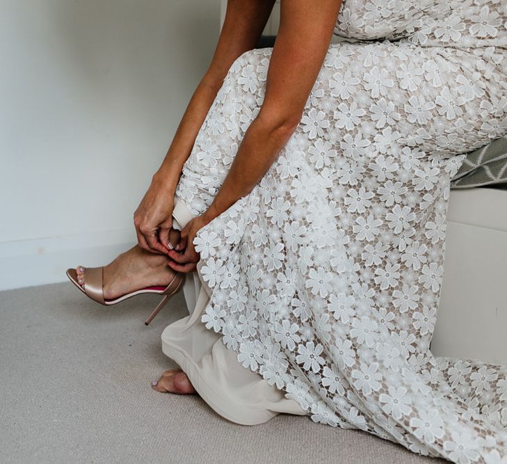 Bride putting on her Gold Oscar Tiye – Satin Champagne Minnie Shoes