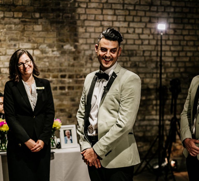 Stylish Groom in Black Trousers and Grey Tuxedo Jacket Waiting at the Altar