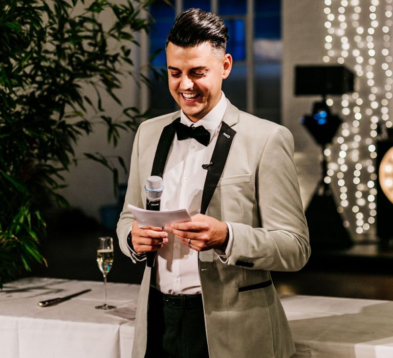 Stylish Groom in Black Trousers and Grey Tuxedo Jacket Giving His Wedding Speech