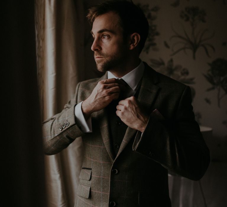 Groom in brown check suit on the wedding morning