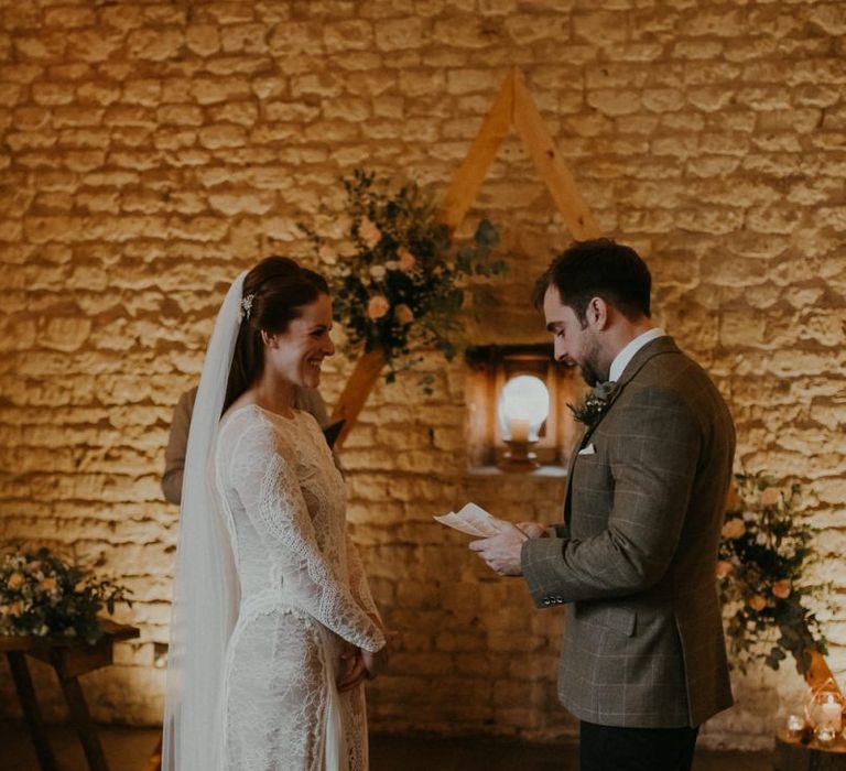 Bride and groom exchanging vows at barn wedding ceremony