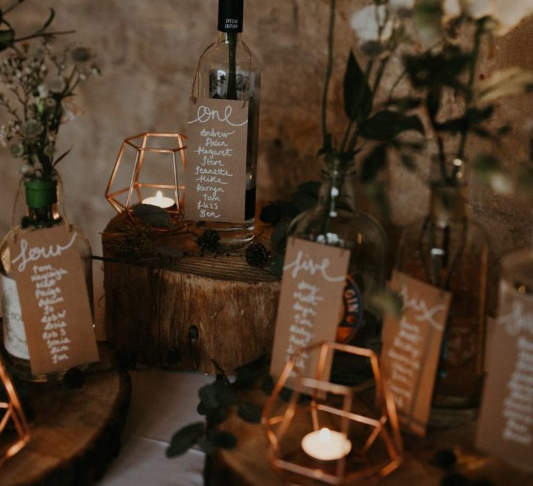 Rustic table plan with tree slices, bottles and terrariums