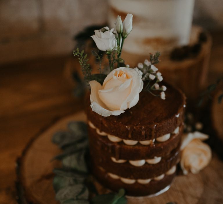 Individual chocolate wedding cake on tree slice with flower decor