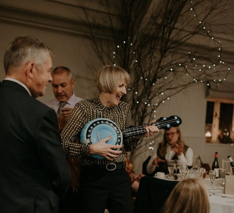 Wedding guest playing with inflatable guitar