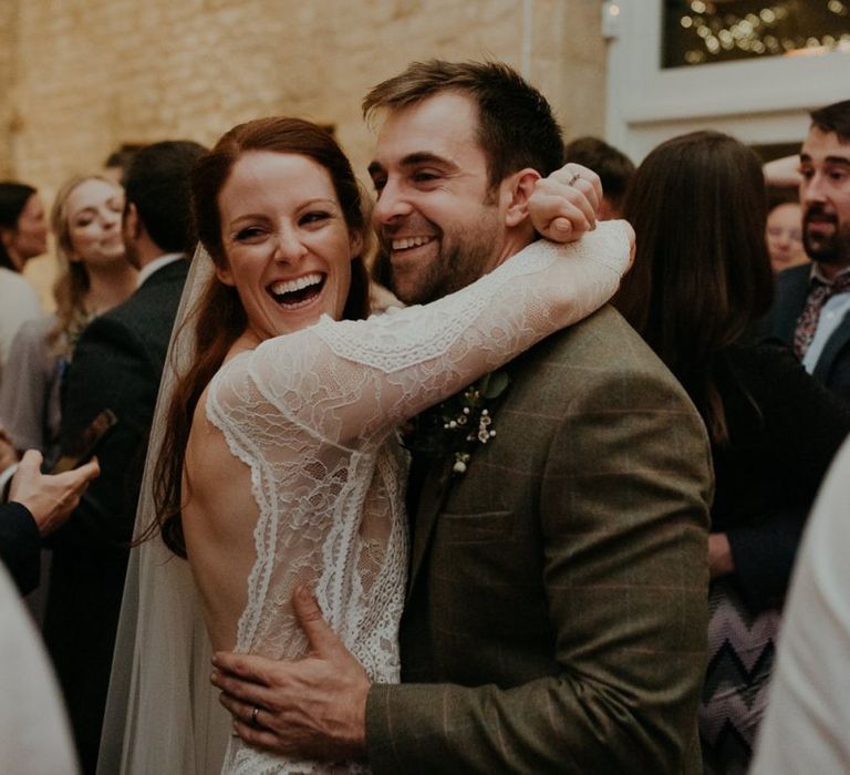 Bride and groom embracing and laughing on the dance floor at Lapstone Barn