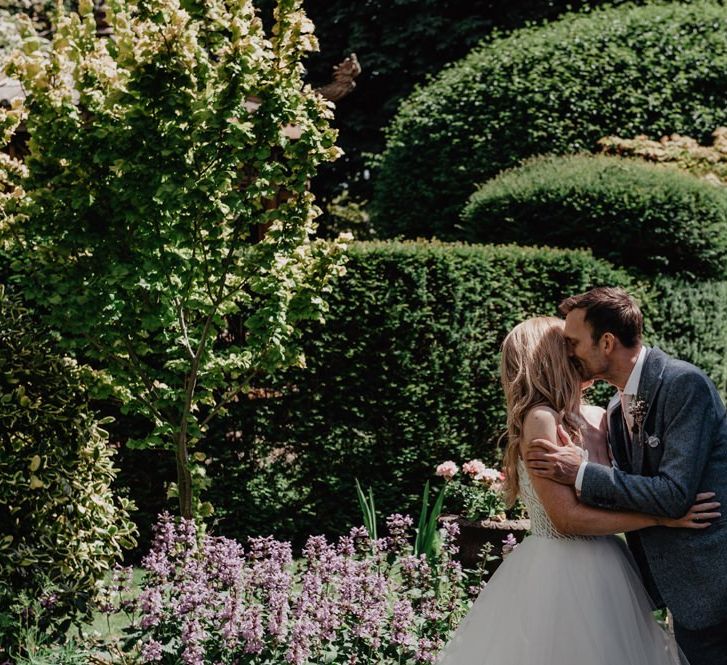 Bride and groom during outdoor ceremony with Prosecco wall