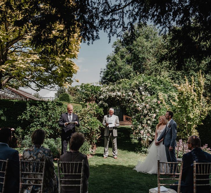 Bride and groom during outdoor wedding  with Prosecco wall