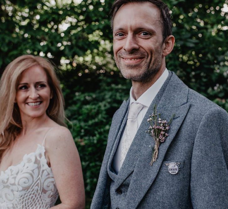 Groom in grey three piece suit with floral buttonhole