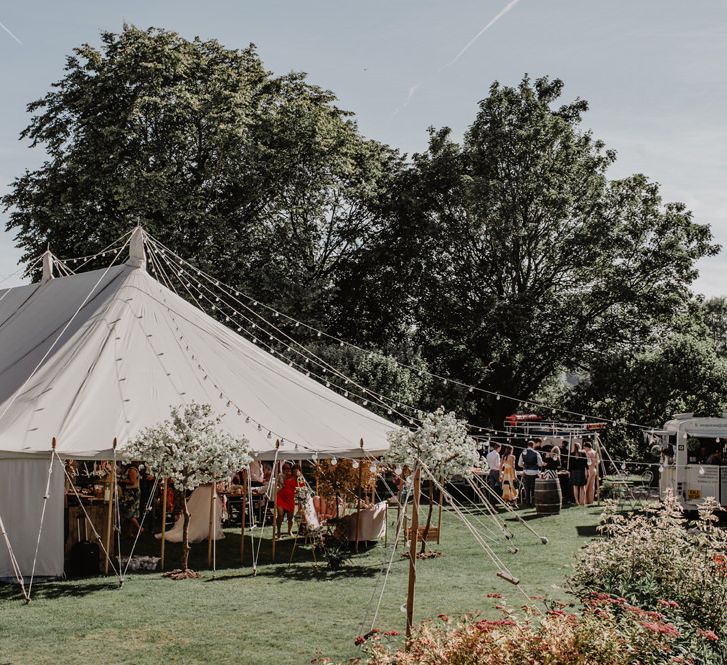 Marquee reception with stunning cherry blossom trees and Prosecco wall