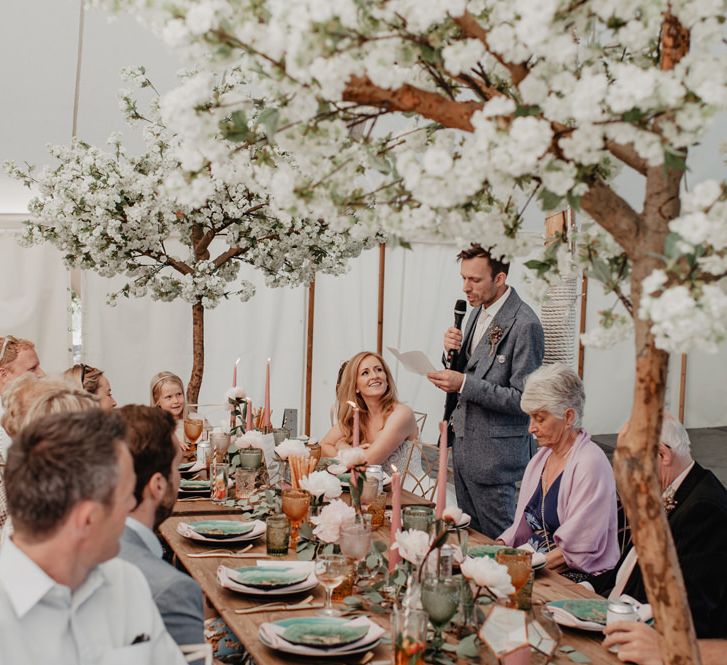 Cherry blossom trees at wedding with Prosecco wall