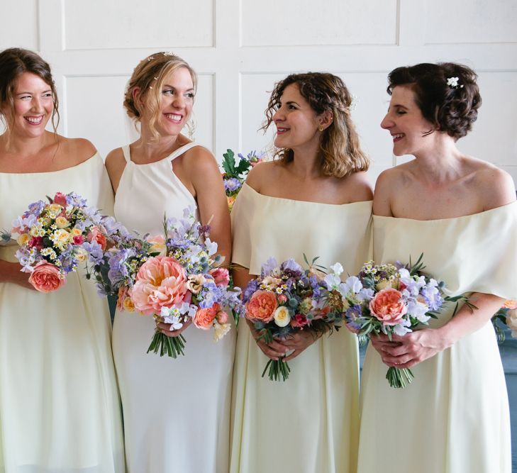 Bridal Party in White Off the Shoulder and Halterneck Dresses with Colourful Bouquets