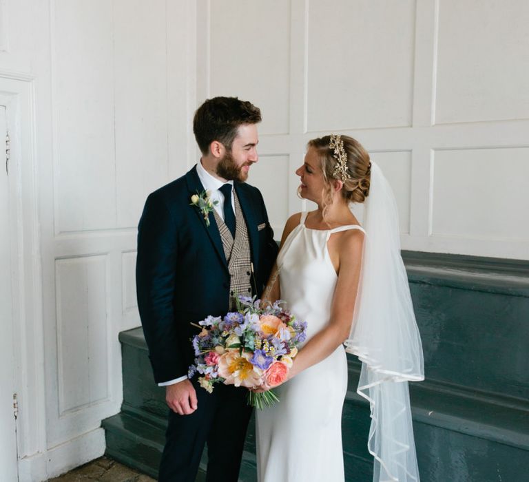 Bride in Minimal Halter Neck Wedding Dress and Groom in Traditional Suit