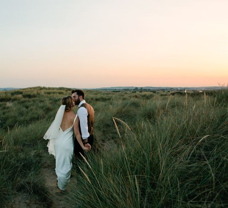 Bride ad Groom Kissing in the Sand Dunes