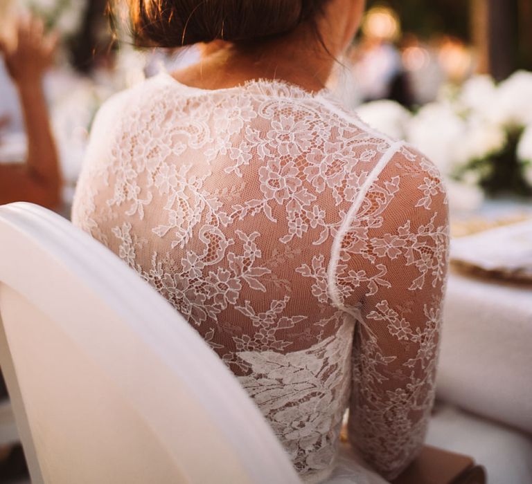 Delicate Lace Back of Brides Anna Kara Bridal Gown with Chic Low Bun Hairstyle