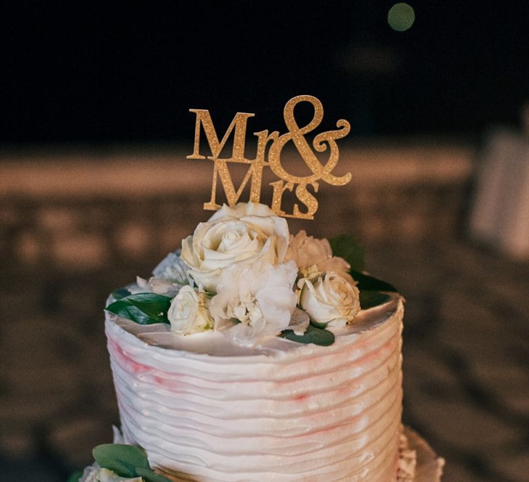 Gold Mr &amp; Mrs Cake Topper on Elegant Wedding Cake with Frosting and Flowers