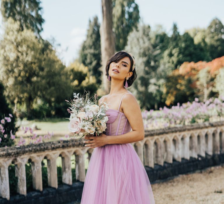 Beautiful Bride in Blush Wedding Dress Holding a Bouquet in White Stiletto Shoes