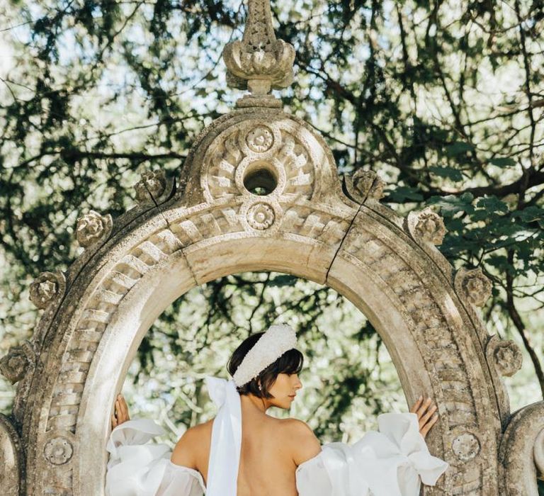 Bride in Strapless Wedding Dress Wearing an Ornate Headdress Tied with Ribbon