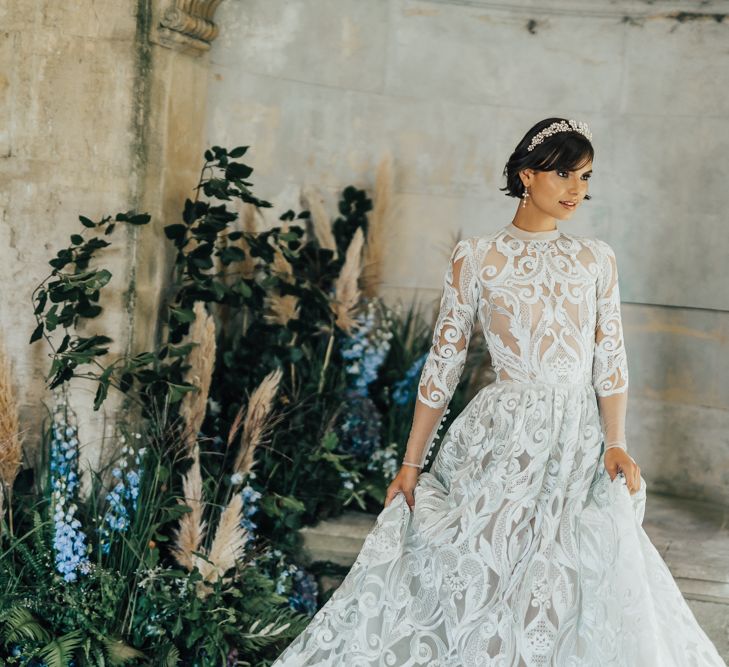 Beautiful Bride in Lace Emma Beaumont Wedding Dress with High Neck and Long Sleeves Wearing a Pearl Wedding Hair Accessory