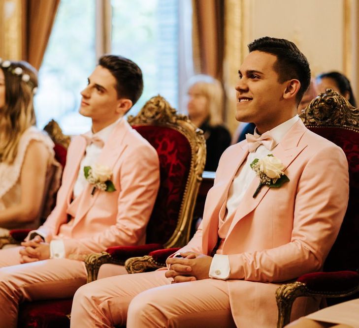 Grooms at intimate ceremony in Paris wearing pink wedding suits