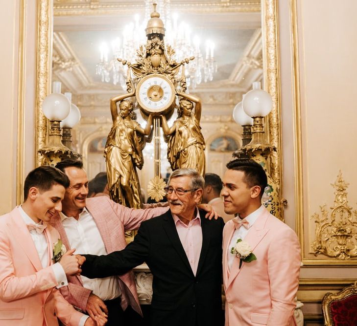 Grooms and relatives enjoy a moment at intimate ceremony with gold and ornate styling