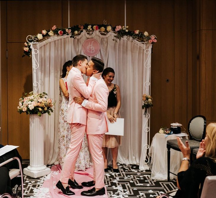 Emotional first kiss during same-sex wedding in Paris with personalised aisle decor and roses