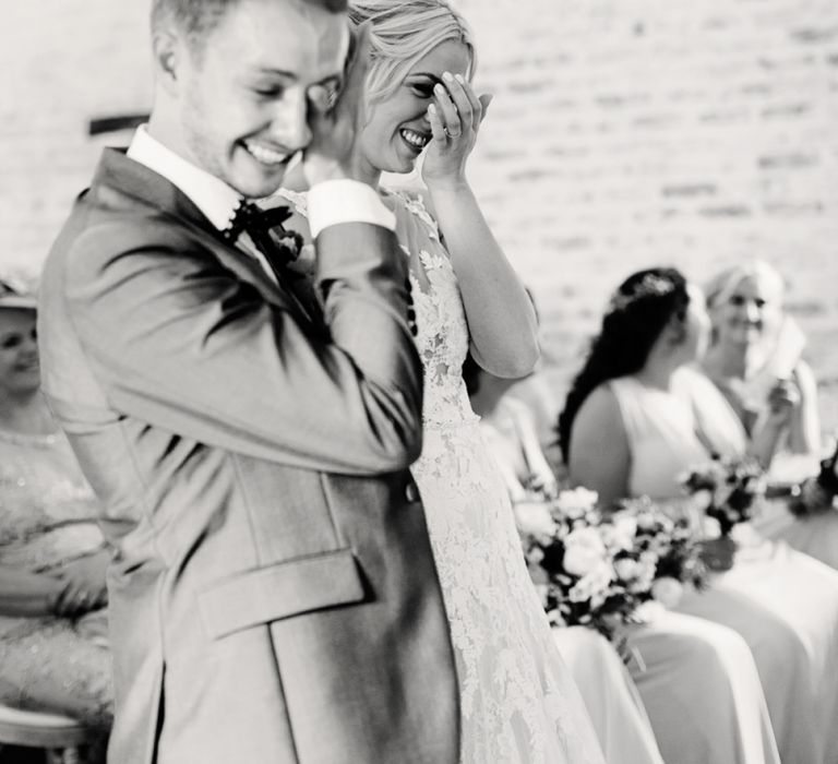 Bride in Lace Pronovias Wedding Dress and Groom in Navy Suit Laughing During the Wedding Ceremony