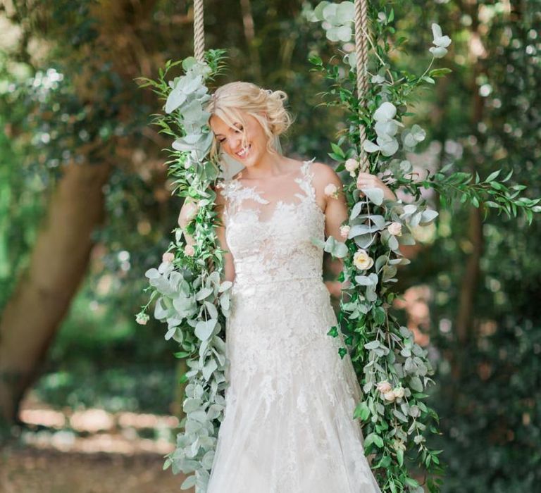 Bride in Lace and Tulle Pronovias Wedding Dress Standing on a Swing Covered in Ivy