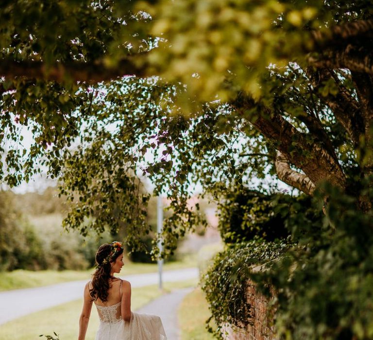 Bride Walking Down the Lane Holding Up Her Sottero &amp; Midgley Wedding Dress