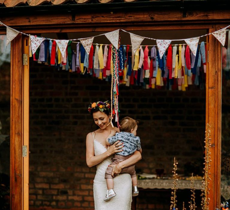 Bride in Lace Sottero &amp; Midgley Wedding Dress Holding Her Infant