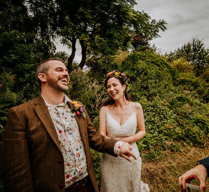 Bride in Sottero &amp; Midgley Wedding Dress and Colourful Flower Crown and Groom in Brown Wool Suit and Floral Shirt