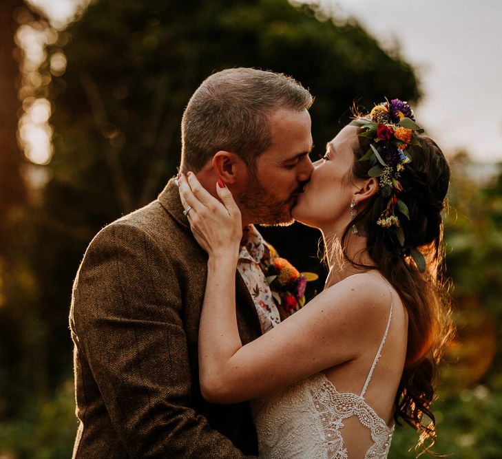 Bride in Sottero &amp; Midgley Wedding Dress and Colourful Flower Crown and Groom in Brown Wool Suit and Floral Shirt