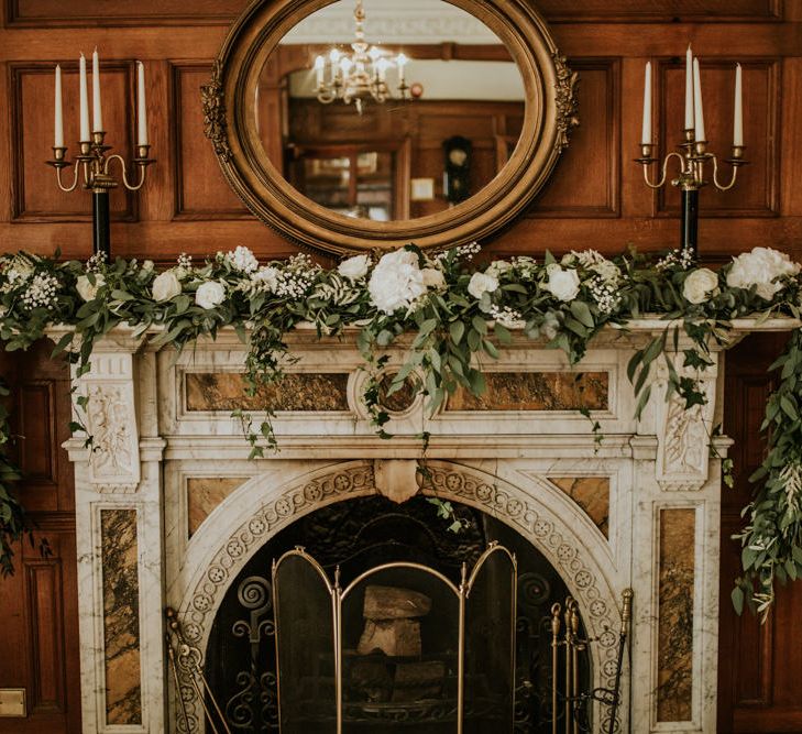 Greenery &amp; White Fireplace Garland Wedding Flowers | Green, White &amp; Gold Wedding at Buckland Tout Saints, Devon |  Darina Stoda Photography