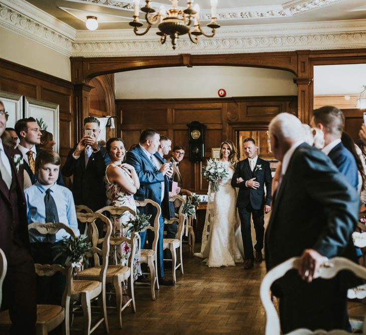 Wedding Ceremony | Bridal Entrance in Pronovias Oringo Lace Bridal Gown &amp; Cape | Green, White &amp; Gold Wedding at Buckland Tout Saints, Devon |  Darina Stoda Photography