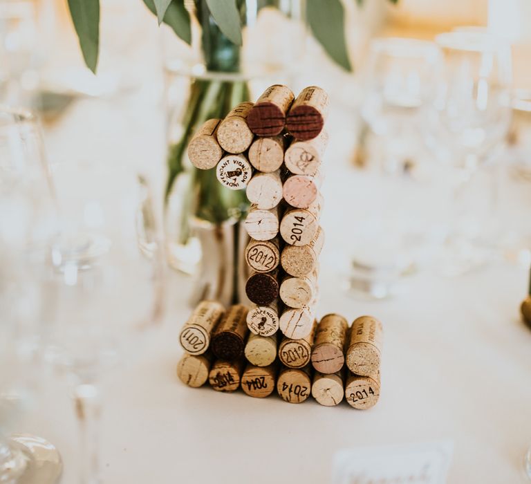 Cork Table Number Wedding Decor | Green, White &amp; Gold Wedding at Buckland Tout Saints, Devon |  Darina Stoda Photography