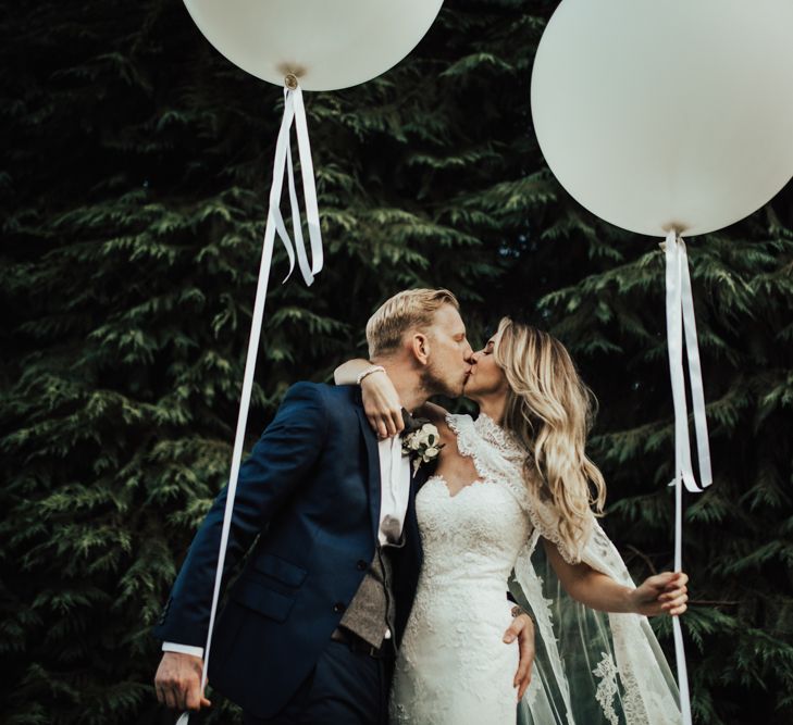 Giant Balloons | Bride in Pronovias Oringo Lace Bridal Gown &amp; Cape | Groom in Blue Marks and Spencer Suit | Green, White &amp; Gold Wedding at Buckland Tout Saints, Devon |  Darina Stoda Photography