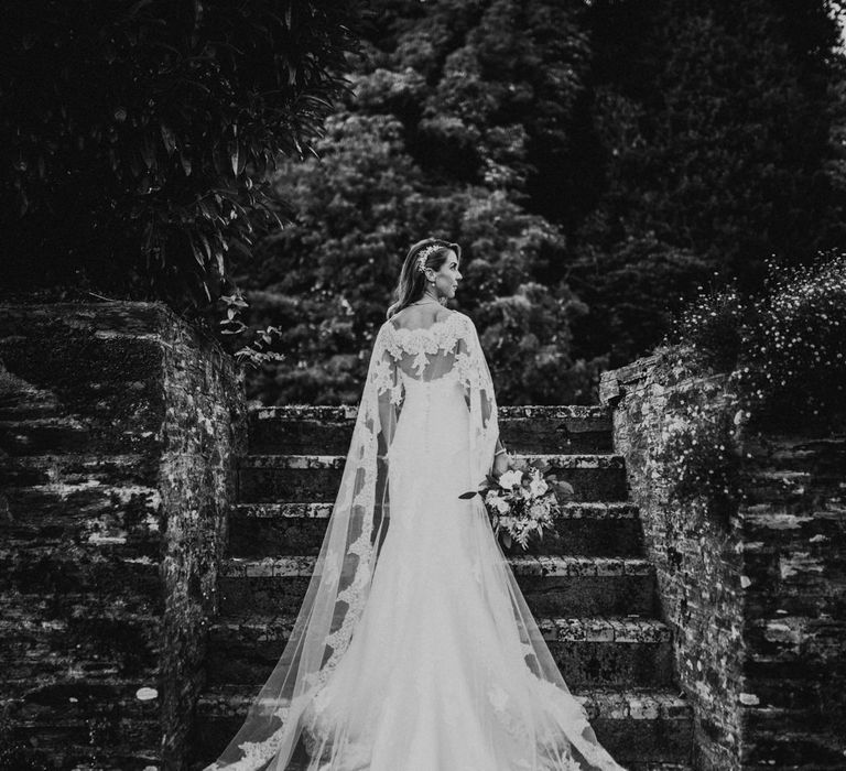 Bride in Pronovias Oringo Lace Bridal Gown &amp; Cape | Green, White &amp; Gold Wedding at Buckland Tout Saints, Devon |  Darina Stoda Photography