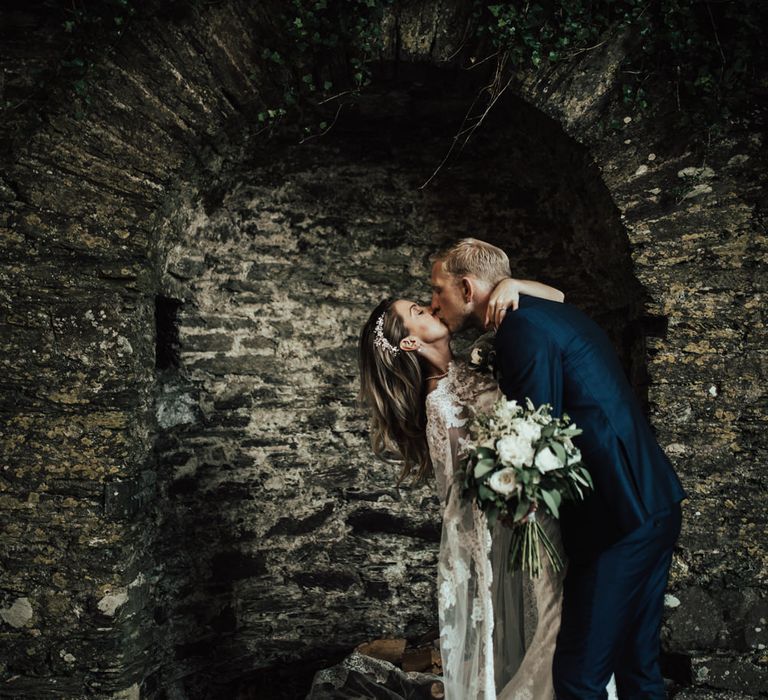 Bride in Pronovias Oringo Lace Bridal Gown &amp; Cape | Groom in Blue Marks and Spencer Suit | Green, White &amp; Gold Wedding at Buckland Tout Saints, Devon |  Darina Stoda Photography