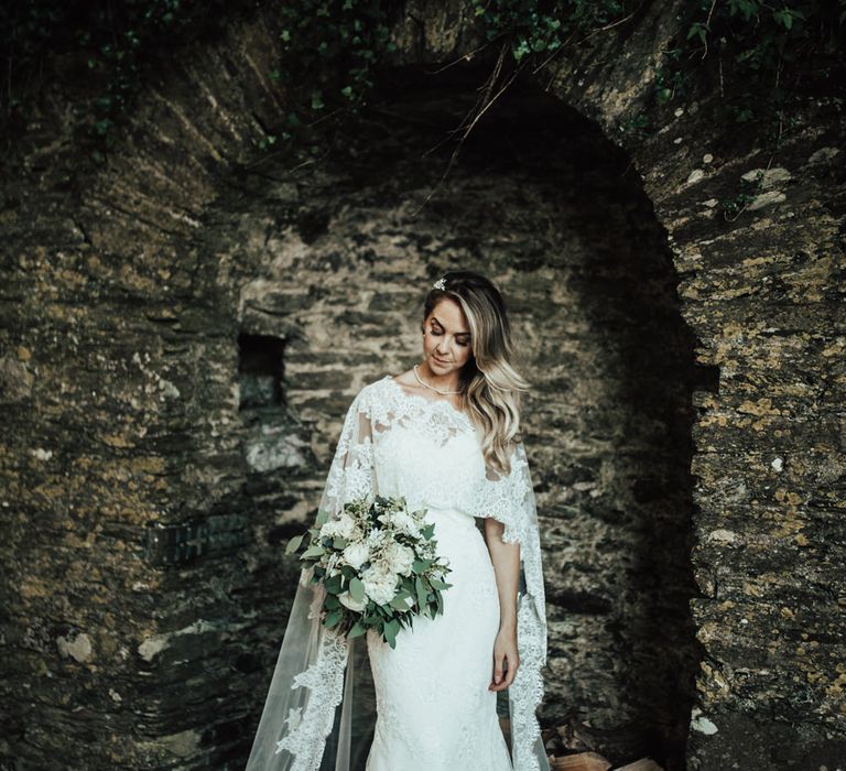 Bride in Pronovias Oringo Lace Bridal Gown &amp; Cape | Green, White &amp; Gold Wedding at Buckland Tout Saints, Devon |  Darina Stoda Photography