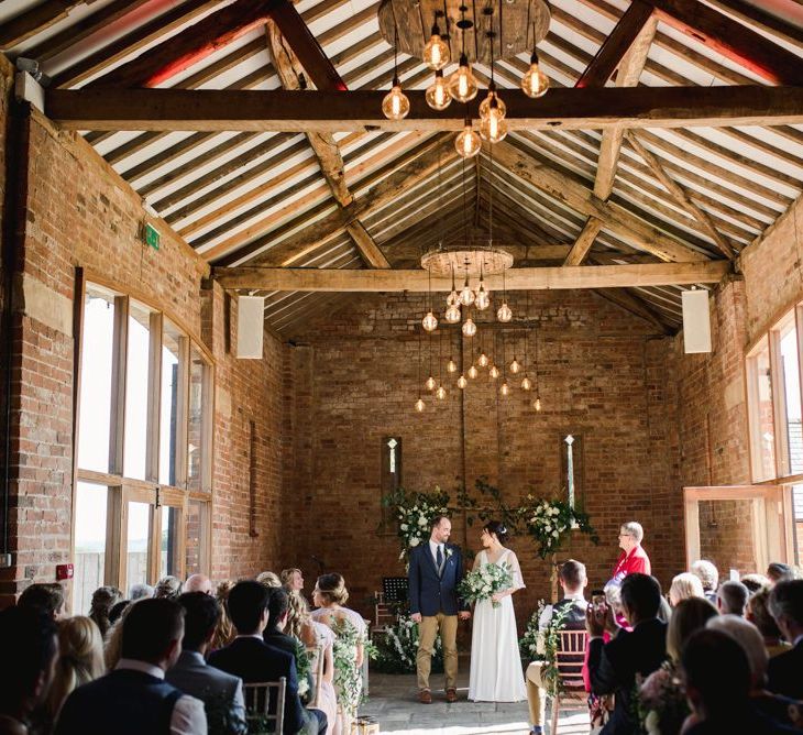 Barn wedding ceremony with white wedding flowers